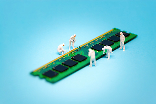 Miniature technicians repairing computer RAM module. Macro photo