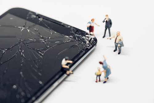 Various people standing around shattered smartphone