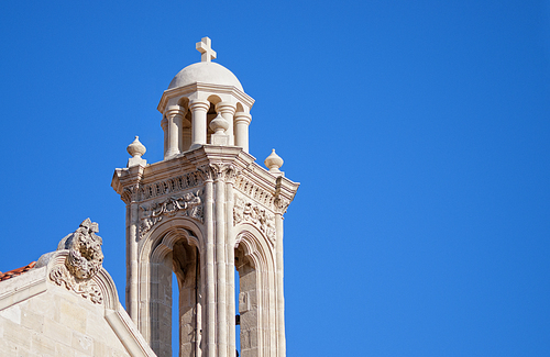 High church bell tower opposite blue sky. Cyprus