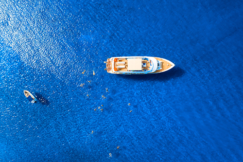 Recreational boats with tourists swimming at sea, overhead shot