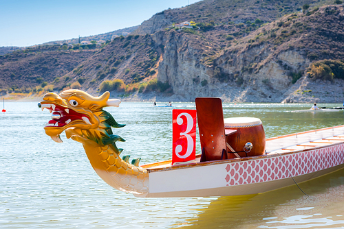 Sport dragon boat with decorated head on a lake
