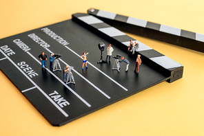 Movie making scene. Crew figurines on a wooden clapper