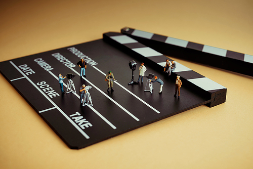 Movie making process. Crew figurines on a wooden clapper