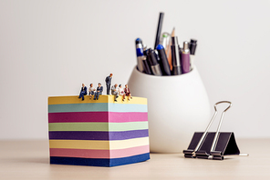 Businesspeople meeting in a miniature office.