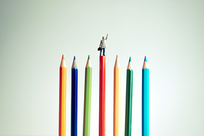 Miniature businessman on top of red pencil. Business concept