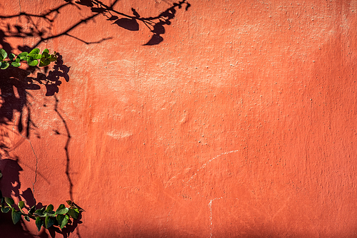 Shabby cement wall covered with red paint
