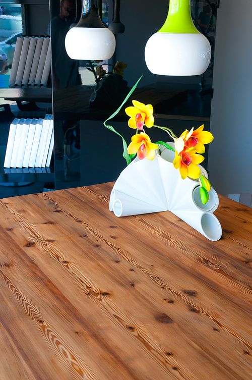 Modern home interior detail. Wooden table with colorful vase