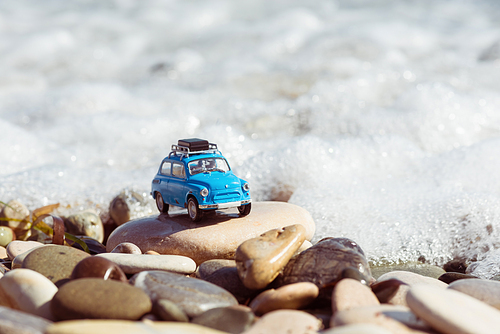 Vintage toy car parked near the sea. Travel concept.