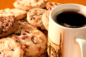 Closeup of chocolate and strawberry cookies with a cup of coffee