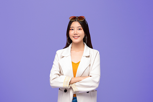 Portrait of young pretty smiling Asian woman in smart casual clothes crossing arms on colorful purple background