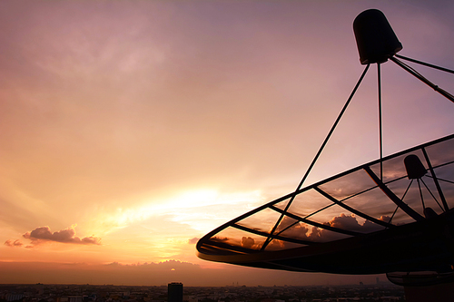 Satellite dish silhouette on twilight sky background