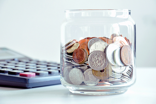 Coins in the glass jar (mixed Asian currencies) - saving concept