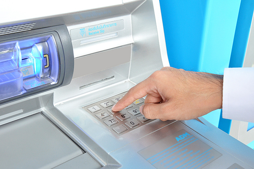 ATM (or Automated Teller Machine ) with hand pressing on the keypad