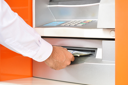 Hand taking (withdraw) money from ATM