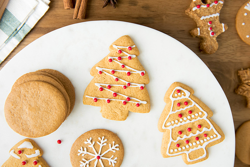 Assorted decorated gingerbread Christmas cookies on white platter, top view