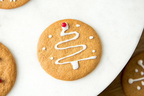 Round homemade gingerbread cookie decorated with icing  in Christmas tree shape on top