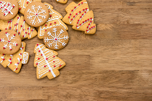 Decorated Christmas gingerbread cookies on wood background, top view border design with copy space