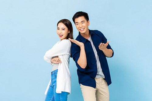 Portrait of happy attractive smiling Asian couple on isolated light blue studio background