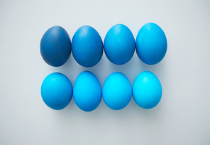 Above view of beautiful robin blue Easter eggs arranged in minimal composition on white background, copy space