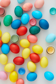 Top view of multi colored Easter eggs arraigned in minimal composition on white background, copy space