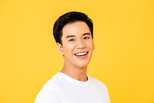 Close up portrait of young handsome Asian man cheerfuly smiling and  in isolated studio yellow background