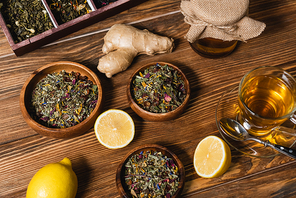 Top view of tea, lemons and honey on wooden surface