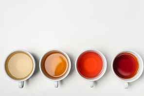 Top view of cups of tea on white background with copy space