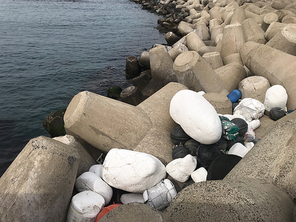 제주도의 방파제로 밀려온 어부들이 사용했던 해양쓰레기더미