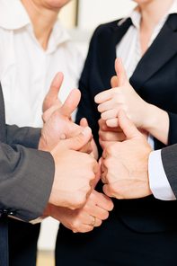 Successful business team showing a thumbs up in a meeting
