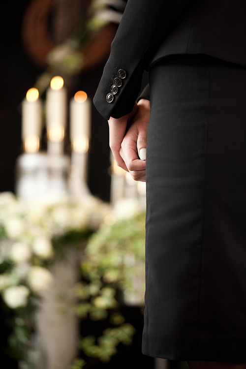 Religion, death and dolor  - woman at urn funeral mourning the death of a loved person