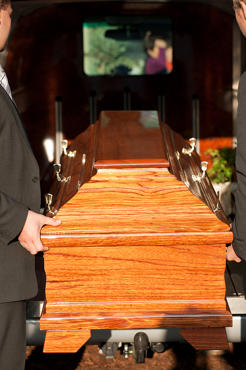 Dolor - Funeral with coffin on a cemetery, the casket carried by coffin bearer