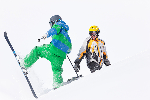 Skier and snowboarder in the snow looking into an alpine winter landscape in anticipation of the next downhill race