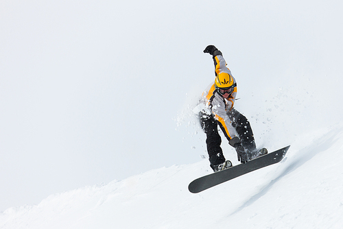 Snowboarder in the alps jumping over an edge of snow grabbing his snowboard
