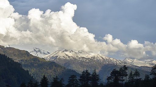 맑은 하늘과 구름, 눈 덮인 산이 어우러진 광활한 풍경.