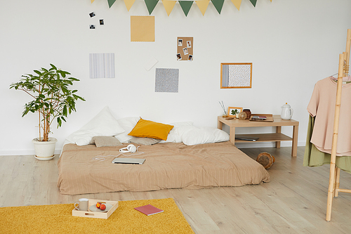 Interior of contemporary bedroom with wall decorated photographs and pictures, mess in room