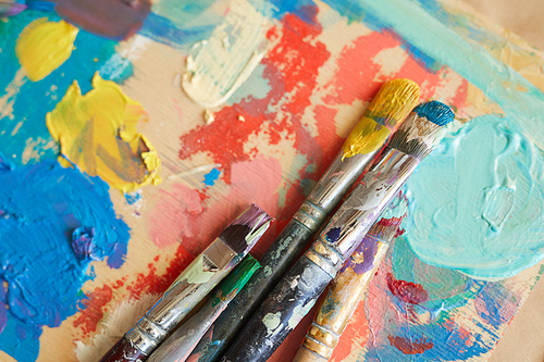 Close-up of finished watercolor painting with paintbrushes on the table