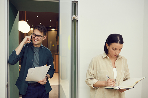 Two office worker busy with their work they talking on the phone and working with documents at office