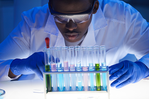 Close-up of African scientist examining the samples in test tubes while working at hospital