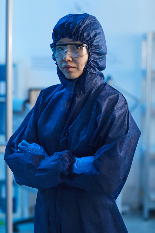 Portrait of Asian female doctor in protective workwear standing with arms crossed and looking at camera at hospital