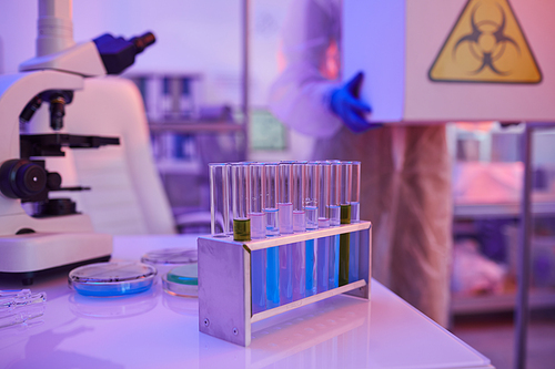 Image of test tubes with different liquid and microscope are on the table in the laboratory