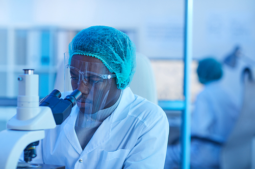 African doctor examining analysis with microscope at the laboratory