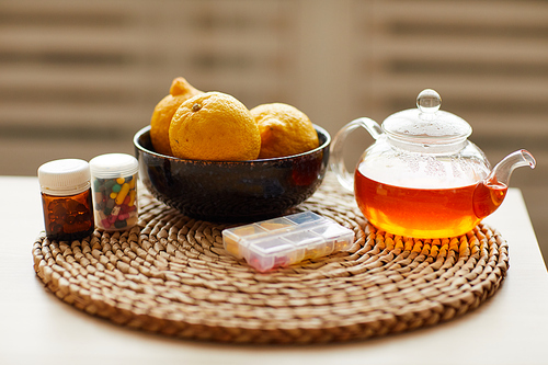 Close-up of table with hot tea lemons and vitamins from epidemic and colds