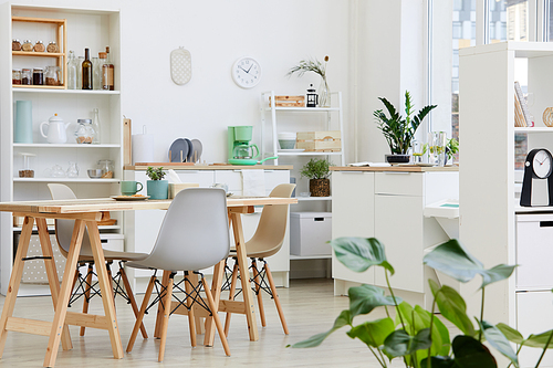 Image of white modern kitchen with big table and modern chairs in the house