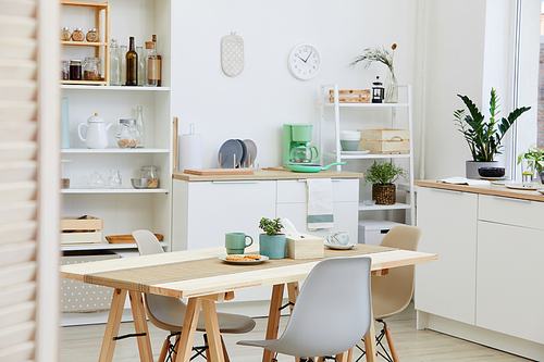 Image of kitchen table with cup of coffee with biscuits on it in the domestic kitchen at home