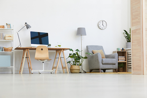 Image of workplace with computer monitor and armchair in the living room at home