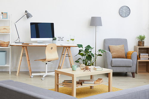 Image of living room with workplace with computer monitor on it and other modern furniture in the house