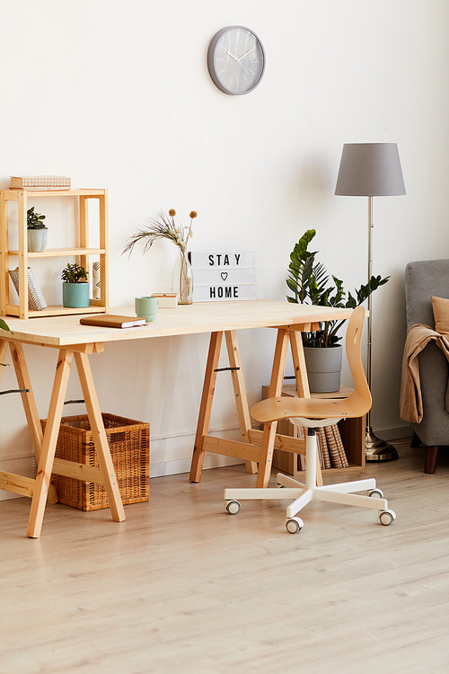 Image of modern wooden table with flowers and notepad in the room at home