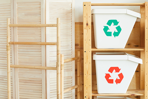 Image of two white plastic garbage bins on the wooden table in workshop