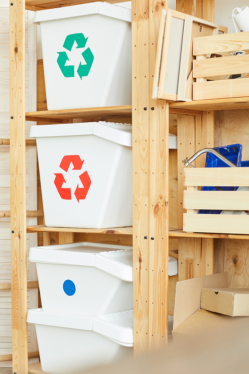 Image of plastic containers for sorted garbage on the wooden shelves