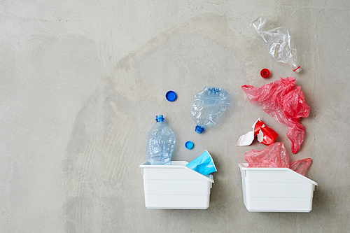High angle view of two plastic containers with plastic bottles and packages isolated on grey background